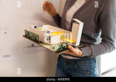 Weibliche Architekten, die an einem Projekt arbeitet, holding Architekturmodell Stockfoto