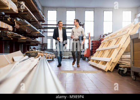 Zwei Geschäftsleute gehen und Sprechen in der Fabrik Abstellraum Stockfoto