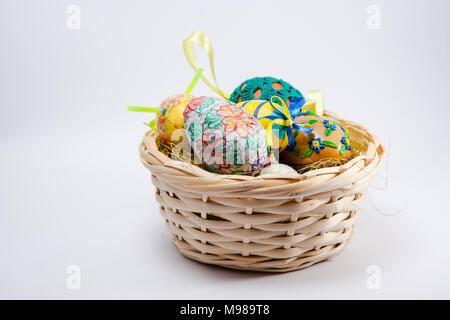 Ostern Eier. Bunte Ostereier in einem Korb auf einem Holztisch. Stockfoto