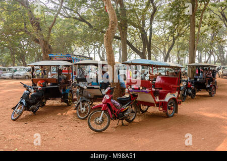 Treiber warten mit ihren geparkten Tuk-tuks (Motorräder mit Anhänger als Taxi eingesetzt) in Kambodscha. Stockfoto