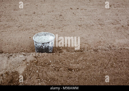 Alte Schaufel in Farbe liegen im Garten zwischen den Reihen abgedeckt. Konzept arbeiten, kopieren. Film Effekt. Stockfoto