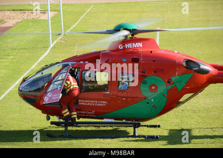 Ein Mitglied der Mannschaft steigt in das Cockpit eines Airbus Hubschrauber der Wales Air Ambulance Service, bevor Sie gestartet ist Stockfoto