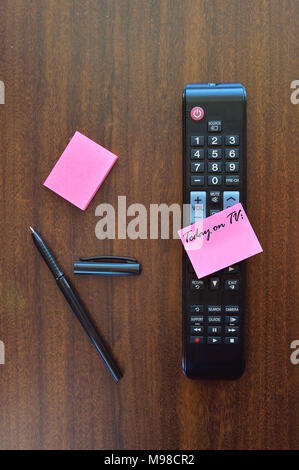 Erinnerung Hinweis über eine TV-Fernbedienung auf einem Holz Tisch Stockfoto