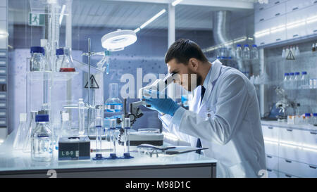 Forschung Wissenschaftler schaut in Mikroskop. Er führt Experimente im modernen Labor. Stockfoto