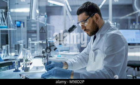 In einem modernen Laboaratory Forschung Wissenschaftler Schreibt sein Experiment Beobachtungen. Stockfoto