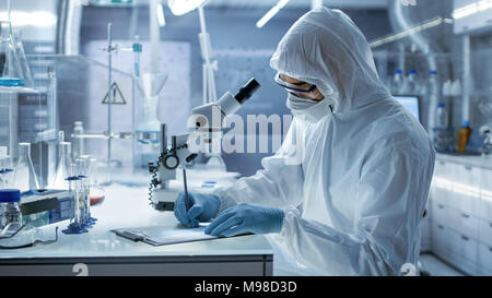 In einem sicheren Hohe Forschung Labor Wissenschaftler schreiben Sie Experiment Ergebnisse. Stockfoto