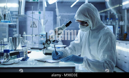 In einem sicheren Hohe Forschung Labor Wissenschaftler schreiben Sie Experiment Ergebnisse. Stockfoto