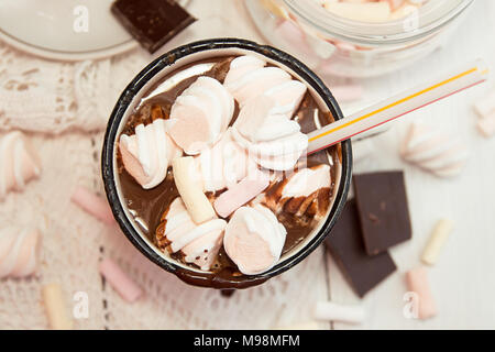 Tasse heiße Schokolade trinken mit Marshmallow Bonbons auf der Oberseite und Kerzen auf weißem Hintergrund. Stockfoto