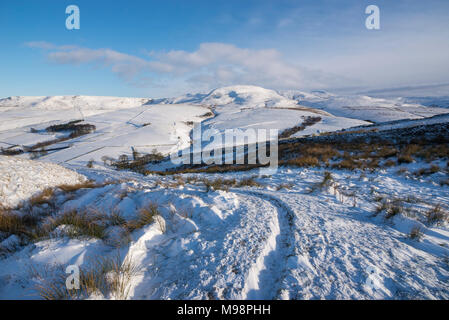 Wanderweg in der Nähe von Hayfield in den Hügeln des Peak District, Derbyshire. Ein schöner Wintermorgen. Die Hänge des Kinder Scout unter einer Schicht von Schnee. Stockfoto