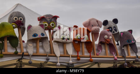 Gestrickte wollene Tier gestaltete Hüte für Kinder zum Verkauf an einem regnerischen Tag im Markt im Freien Stockfoto