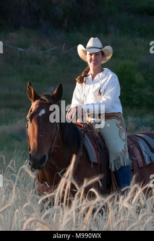 Cowgirl und Pferdetrainer reiten auf dem Land Stockfoto