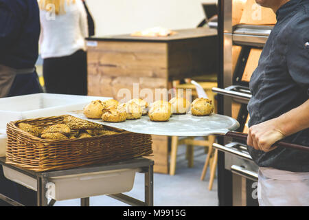 Baker Holding frisch gebackenen Scones in Backofen Gabel Stockfoto