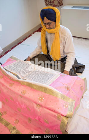 Ein Sikh Priester, ein Granthi, lesen Sri Guru Granth Sahib, dem heiligen Buch der Sikhs. In Richmond Hill in Queens, New York. Stockfoto