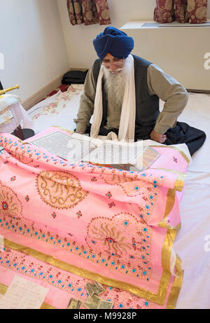 Ein Sikh Priester, ein Granthi, lesen Sri Guru Granth Sahib, dem heiligen Buch der Sikhs. In Richmond Hill in Queens, New York. Stockfoto