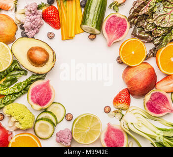 Buntes Obst und Gemüse Rahmen Hintergrund mit der Hälfte der Orangen, Beeren, Ansicht von oben. Gesundes Essen und sauber essen Zutaten Konzept Stockfoto