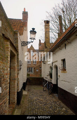 Eine alte Kopfsteinpflasterstraße aus Moerstraat, ehemaligen Armenhaus 'Vette Vispoort', dating von 1434, in Brügge, Westflandern, Belgien Stockfoto