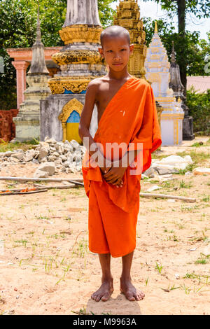 Eine sehr junge Mönch steht außerhalb eines buddhistischen Tempels in einem ländlichen Gebiet von Kambodscha Stockfoto
