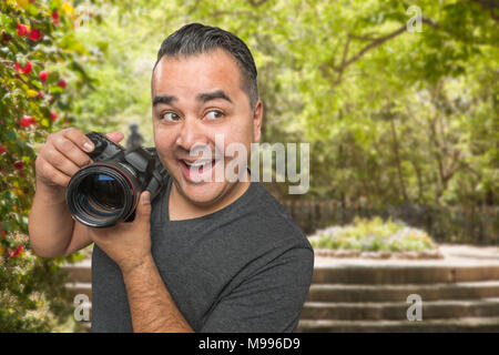Hispanic männlichen jungen Fotografen mit DSLR-Kamera im Freien Stockfoto