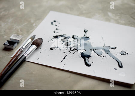 Palette von Schwarz und Weiß malen. ein Blatt weißes Papier mit schwarzem Farbstoff Tinte. Stockfoto
