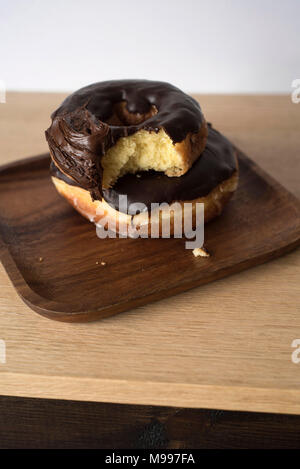 Gestapelte Donuts mit einem Bissen von einem auf einem hellen Hintergrund genommen Stockfoto