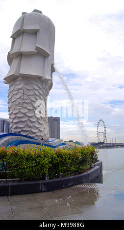 Singapur - APR 2 2015: Der Merlion Brunnen und die Skyline von Singapur. Merlion ist ein Fabelwesen mit dem Kopf eines Löwen und der Körper eines Fisches. Als Symbol der Stadt gesehen Stockfoto