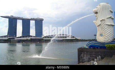 Singapur - APR 2 2015: Der Merlion Brunnen und die Skyline von Singapur. Merlion ist ein Fabelwesen mit dem Kopf eines Löwen und der Körper eines Fisches. Als Symbol der Stadt gesehen Stockfoto