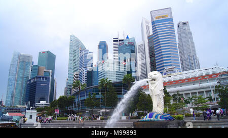 Singapur - APR 2 2015: Der Merlion Brunnen und die Skyline von Singapur. Merlion ist ein Fabelwesen mit dem Kopf eines Löwen und der Körper eines Fisches. Als Symbol der Stadt gesehen Stockfoto