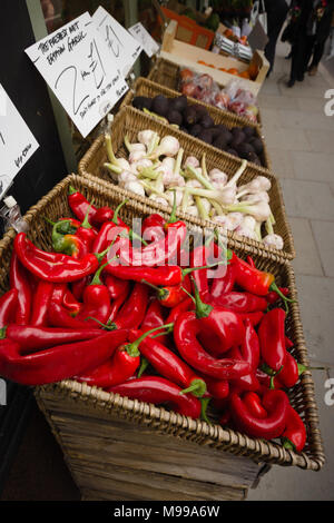 Bunte Show von hellen roten Chilis, Knoblauch und Avocados auf einem Gehsteig, außerhalb des unabhängigen grünen Lebensmittelgeschäft shop in Großbritannien Stockfoto