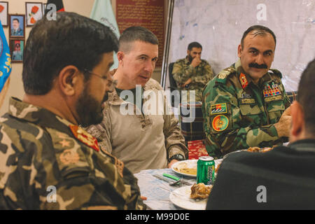 Us Marine Brig. Gen. Benjamin T. Watson, Kommandierender General der Task Force Südwesten (TFSW) und Maj Gen Wali Mohammed Ahmadzai, Kommandierender General des Afghanischen Nationalen Armee 215 Corps, hören Sie zu wichtigen Führungskräften innerhalb der afghanischen nationalen Verteidigungs- und Sicherheitskräfte (ANDSF) während einer Mahlzeit Sharing bei Bost Flugplatz, Afghanistan, Jan. 25, 2018. Top Berater aus TFSW und führenden Persönlichkeiten aus dem ANDSF kamen zusammen, um zu diskutieren, zu Aktionen für den Betrieb Maiwand 11. Sie erörterten ferner die vorläufigen Sicherheitslösungen weitere Stärkung der Helmand Sicherheit und Stabilität in der Region. Stockfoto