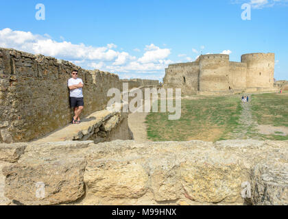 Ein junger Mann im weißen T-Shirt und Sonnenbrille steht auf der Mauer der Festung 2018 Stockfoto