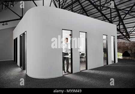 Unternehmer im modernen Konferenzraum Blick aus Fenster Stockfoto