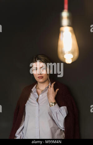 Junge Frau mit leuchtenden Glühbirne Stockfoto