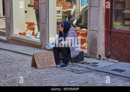 Dezember 23 2.108; Toledo, Spanien: Eine traurige unbekannter obdachlose Frau sitzt in einem Karton bitten, betteln um Geld, um ihre Kinder in contr zu essen Stockfoto