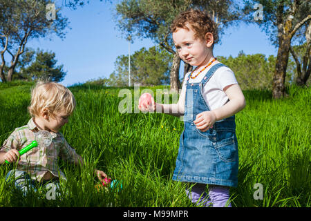 Zwei süße Kleinkinder an Ostern Jagd auf der grünen Wiese Stockfoto