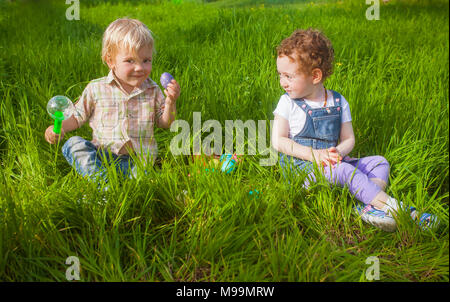 Zwei adorable Kleinkinder spielen mit zu Ostern Eier Jagd Stockfoto