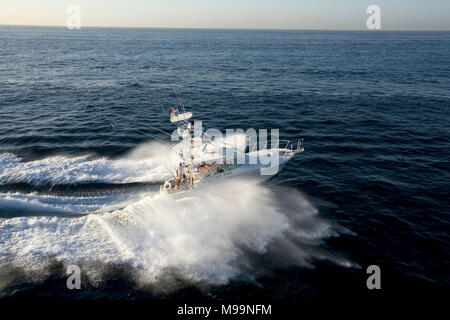 Boot bricht eine Welle Stockfoto