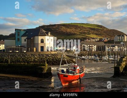 Den Hafen und die Küste von Aberystwyth Wales Februar 2013 mit roten Fischerboot Stockfoto