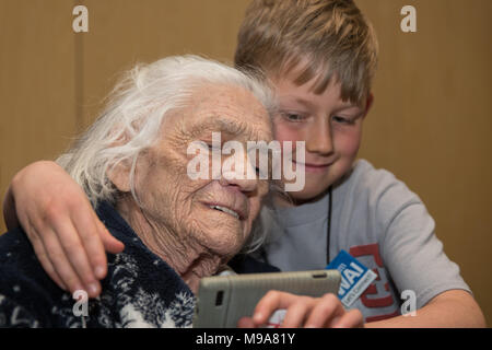 Reno, Nevada, USA. 23 Mär, 2018. MILLICENT PETERSON Jungen und acht Jahre alten Ventilator, DANIEL RICKMAN (r) die Anzeige von Fotos auf einem Smartphone folgenden Auftritt des Jungen auf der 29. jährlichen Frauen in der Luftfahrt International (WAI) Konferenz am Reno-Sparks Convention Center in Reno, Nevada, am Freitag, 23. März 2018. Junge flog mit den Frauen Airforce Service Piloten (WASP) im Jahr 1944. Die Organisation wird manchmal als Women's Army Service Piloten bezeichnet. Jungen ihre Flügel von General Henry "Hap" Arnold. Mehr als 25.000 Frauen angewendet für die Wespe im September 1942 beginnen, erhalten: 1.830 waren Stockfoto