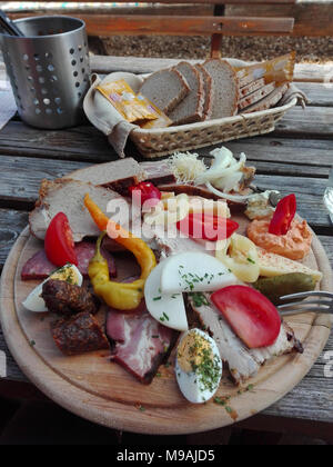 Traditionelle Brettljausn mit Brot und eine Menge Aufschnitt auf hölzernen Tisch in Österreich Stockfoto