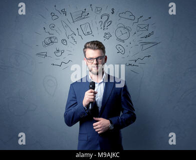 Geschäftsmann sprechen in das Mikrofon mit gemischten Doodles über seinem Kopf Stockfoto