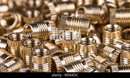 Bronze Gewindeeinsätze als Hintergrund. Close-up dekorative Haufen vom goldenen Metallteilen. Bau, Bauen, Speichern oder Maschinenbau Idee. Stockfoto