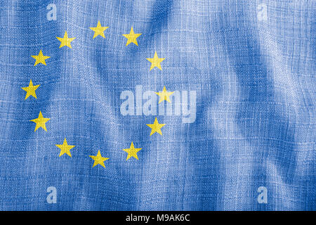 EU-Zeichen auf dem Hintergrund der blauen Wellenlinien Gewebe. Dekorative Textur mit gelben Sternen und Kopieren. Idee der Bewegung, Einschränkung und Recht in der Europäischen Union. Stockfoto