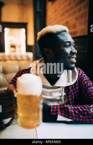 Gerne schönen afrikanischen amerikanischen Jungen Mann Bier trinken. Stockfoto