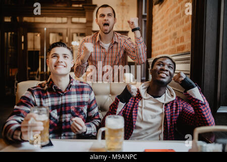 Männer in der Kneipe watcing Fußballspiel und Bier trinkt. Stockfoto