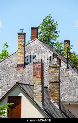 Schornsteine auf dem Schiefer Dach eines alten Hauses Stockfoto