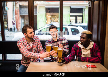 Junge Männer gerne Bier trinken und reden in ein Café oder eine Kneipe Stockfoto