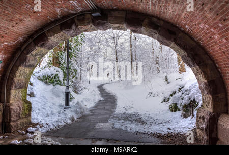 Eine idyllische Winterlandschaft von unten Eastwood Arch gesehen nach einem historischen Frühling Schneesturm in Prospect Park, Brooklyn