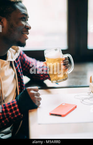 Stattliche Afro-amerikanische trinkt Bier im Pub ruhen Stockfoto