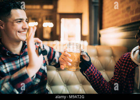 Jungen Kerl hält Autoschlüssel und die Ablehnung von Bier aus seinem Freund in der Kneipe zu trinken Stockfoto