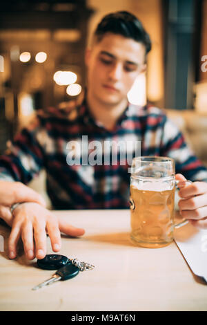 Zugeschnittenes Bild von betrunkenen Mann Autoschlüssel und sein Freund ihn stoppen Stockfoto